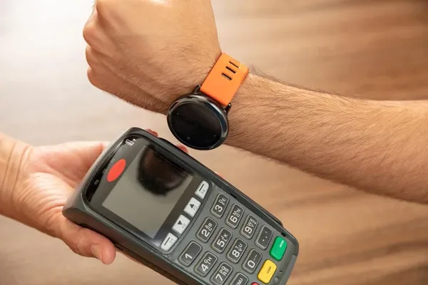 Smartwatch making contactless payment at store terminal using NFC