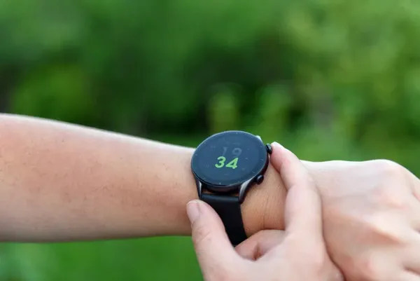 Smartwatch AMOLED display visible in direct sunlight showing fitness stats